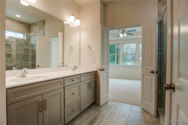 bathroom with double vanity, a shower stall, and a sink