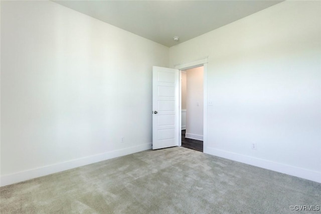 spare room featuring carpet and baseboards