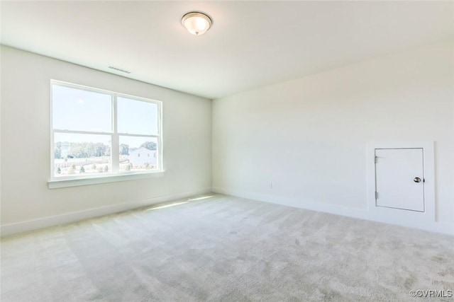 carpeted spare room with visible vents and baseboards