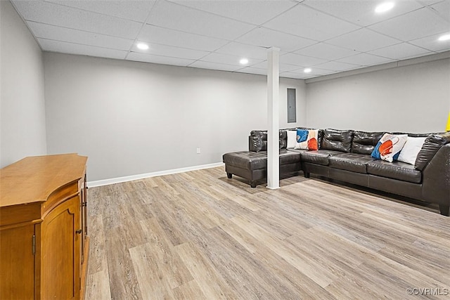 living room featuring recessed lighting, a drop ceiling, baseboards, and light wood finished floors