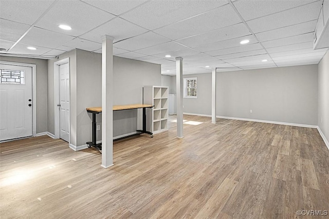 basement with light wood-style flooring, recessed lighting, a paneled ceiling, and baseboards