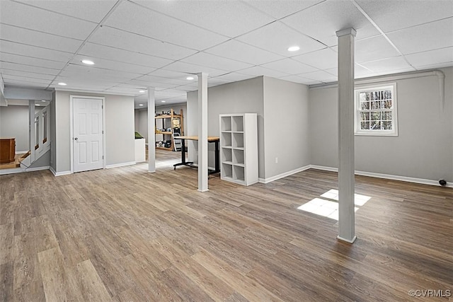 below grade area with baseboards, wood finished floors, and stairs