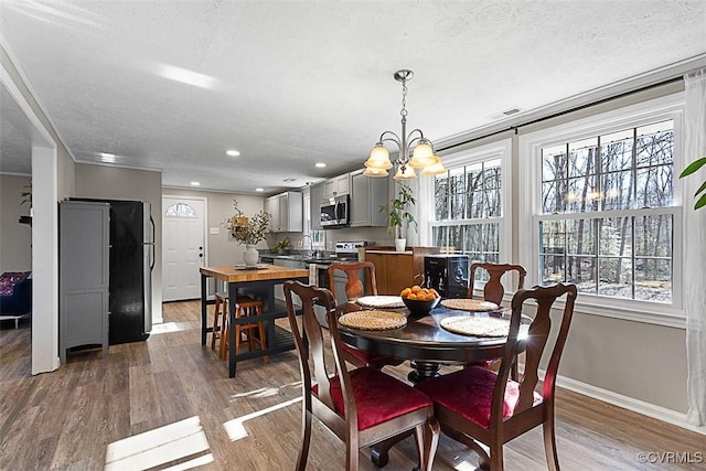 dining area with plenty of natural light, wood finished floors, and a chandelier