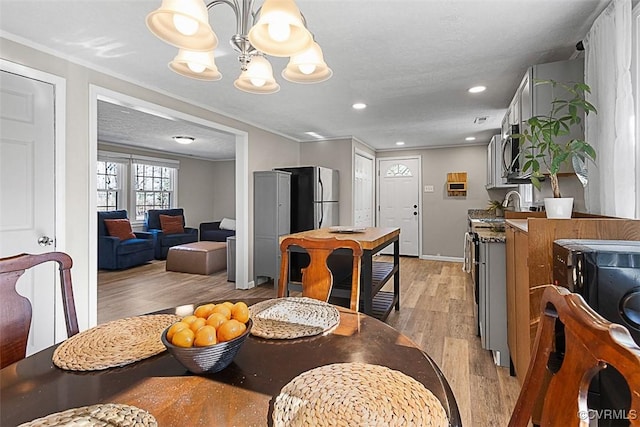 dining area with light wood-style flooring, recessed lighting, baseboards, and a chandelier