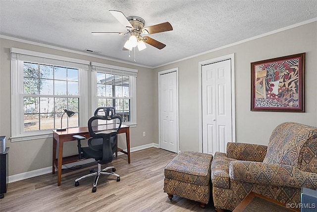 home office featuring light wood-type flooring, ceiling fan, and crown molding