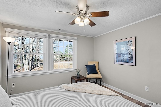 bedroom with wood finished floors, a textured ceiling, baseboards, and ornamental molding