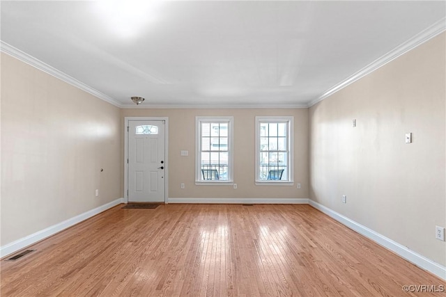 foyer entrance with ornamental molding, light wood-type flooring, visible vents, and baseboards