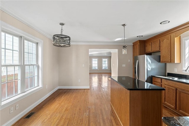 kitchen featuring brown cabinetry, a center island, stainless steel refrigerator with ice dispenser, and light wood finished floors