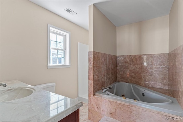 bathroom with visible vents, vanity, and a whirlpool tub