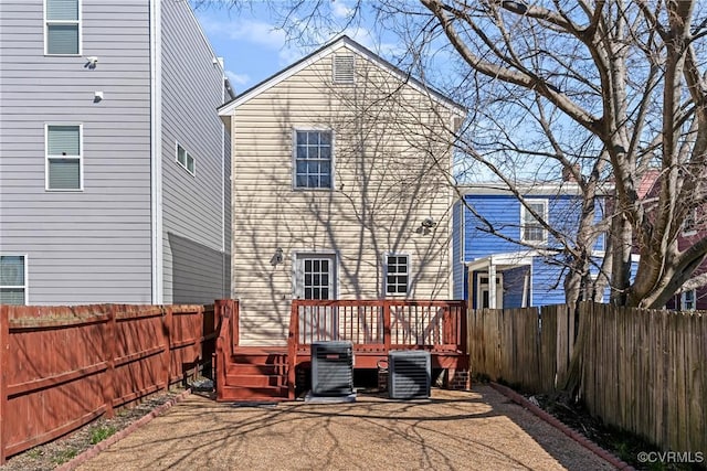 back of property with cooling unit, a fenced backyard, and a wooden deck