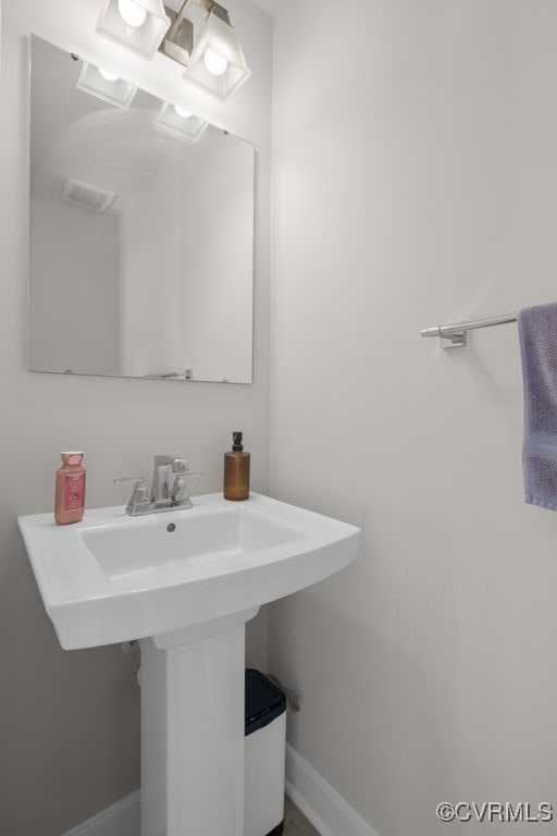 bathroom with a sink and baseboards