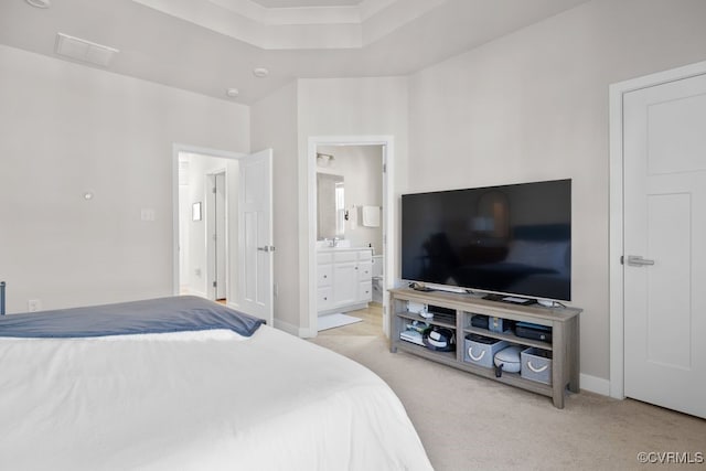 bedroom with light carpet, baseboards, and ensuite bathroom