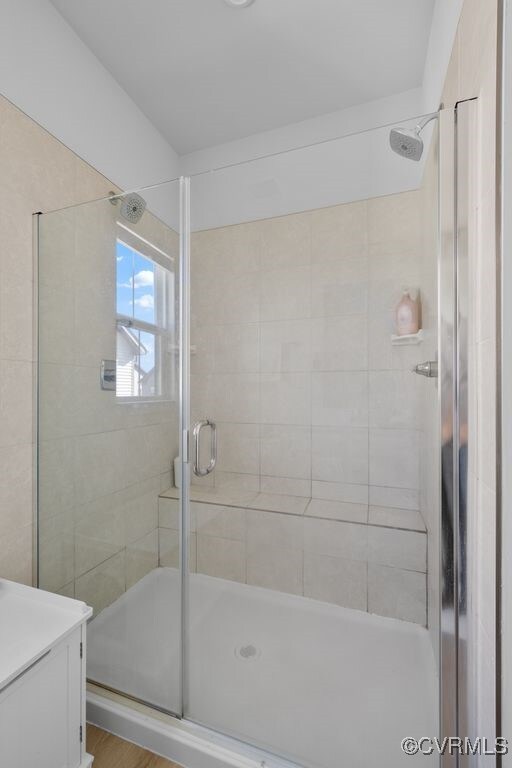 bathroom featuring a shower stall and vanity