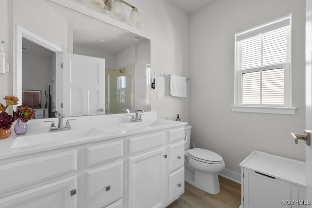 full bath featuring toilet, a stall shower, a sink, and wood finished floors