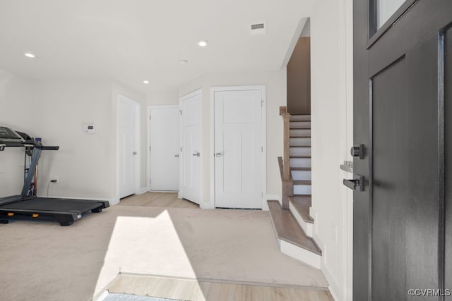 exercise room with recessed lighting, visible vents, light wood-style floors, light carpet, and baseboards