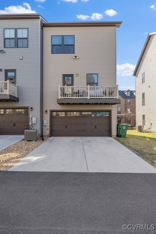 view of front of property with a garage, driveway, and central air condition unit