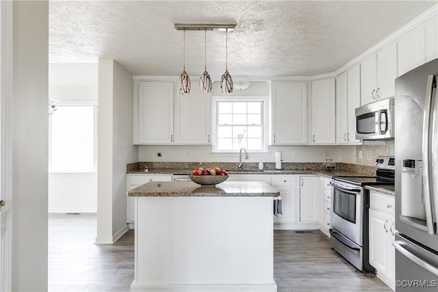 kitchen with light wood-style floors, white cabinetry, appliances with stainless steel finishes, and a sink