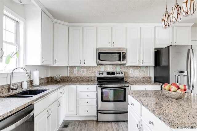 kitchen with stainless steel appliances, white cabinets, and a sink