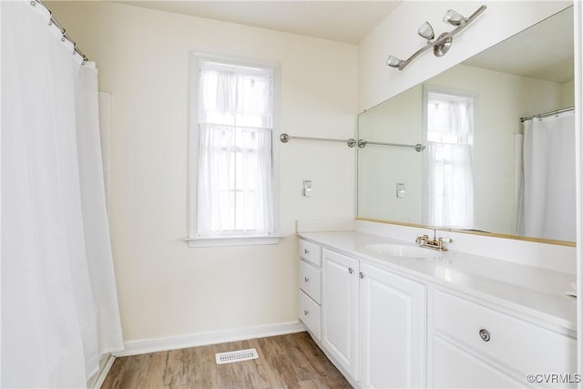 bathroom with wood finished floors, vanity, visible vents, and baseboards