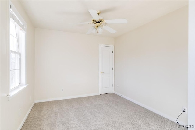 unfurnished room featuring ceiling fan, baseboards, and light colored carpet