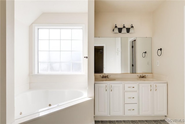 bathroom featuring a healthy amount of sunlight, a sink, a whirlpool tub, and double vanity