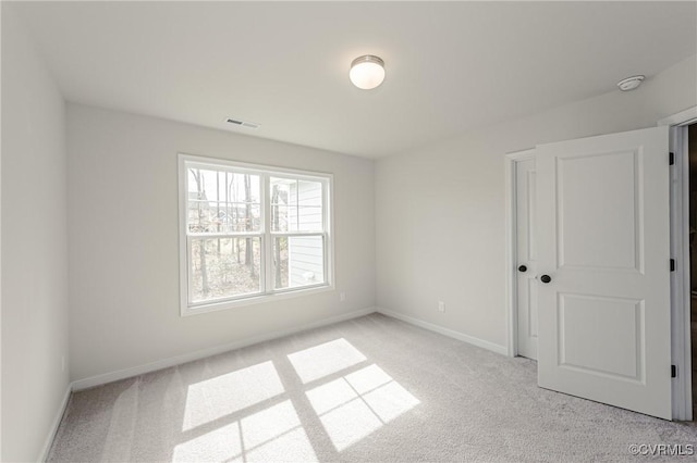 unfurnished bedroom with baseboards, visible vents, and light carpet