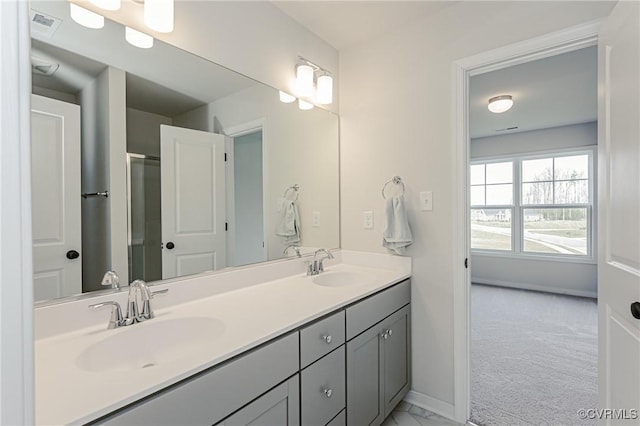 bathroom featuring double vanity, baseboards, and a sink