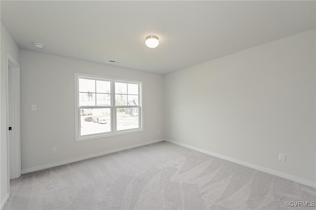 unfurnished room featuring baseboards, visible vents, and light colored carpet