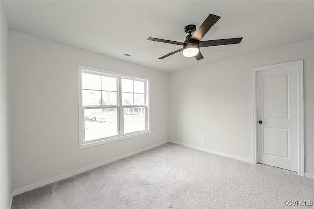 empty room featuring visible vents, a ceiling fan, baseboards, and light colored carpet