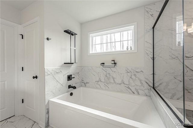bathroom with a garden tub, marble finish floor, and a shower