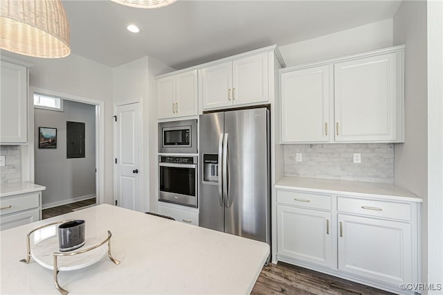 kitchen with tasteful backsplash, wood finished floors, light countertops, stainless steel appliances, and white cabinetry