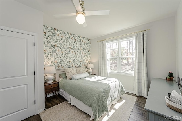 bedroom with a ceiling fan, baseboards, and wood finished floors