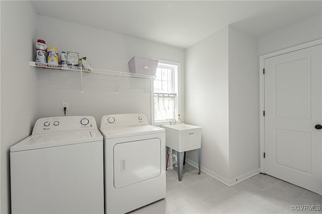 clothes washing area with washing machine and clothes dryer, laundry area, and baseboards