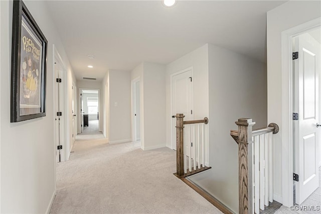 hallway with baseboards, light colored carpet, recessed lighting, and an upstairs landing