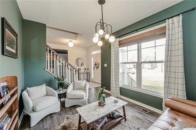living area featuring stairway, baseboards, plenty of natural light, and visible vents