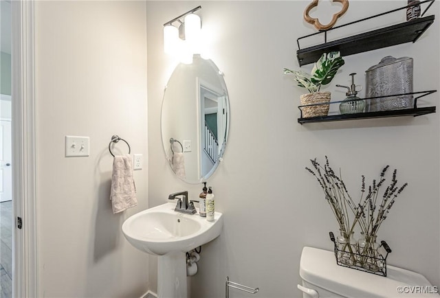 half bathroom with toilet and baseboards