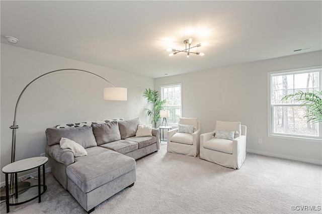 living room featuring light colored carpet, baseboards, a chandelier, and visible vents