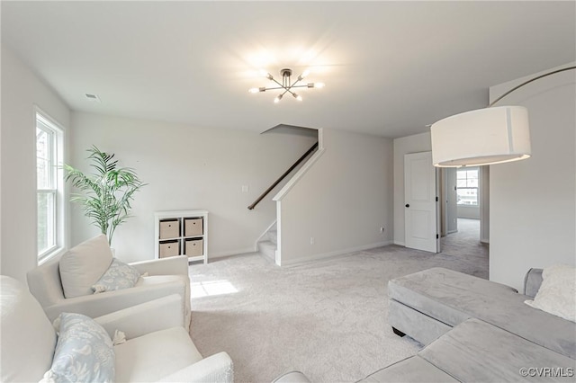carpeted living area featuring baseboards and stairs