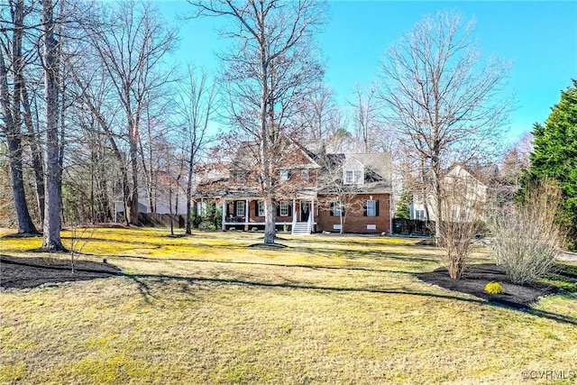 rear view of property featuring brick siding and a lawn