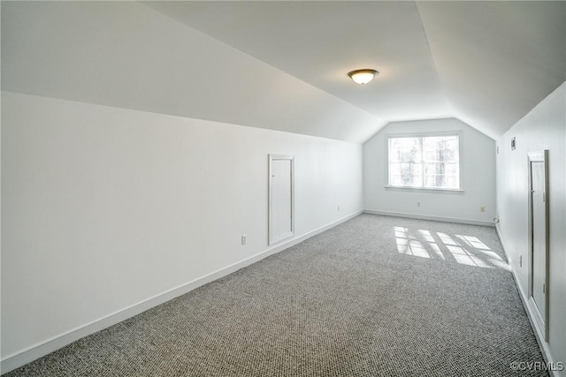 additional living space with carpet flooring, baseboards, and vaulted ceiling