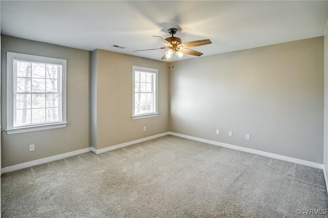 carpeted spare room featuring visible vents, baseboards, and a ceiling fan