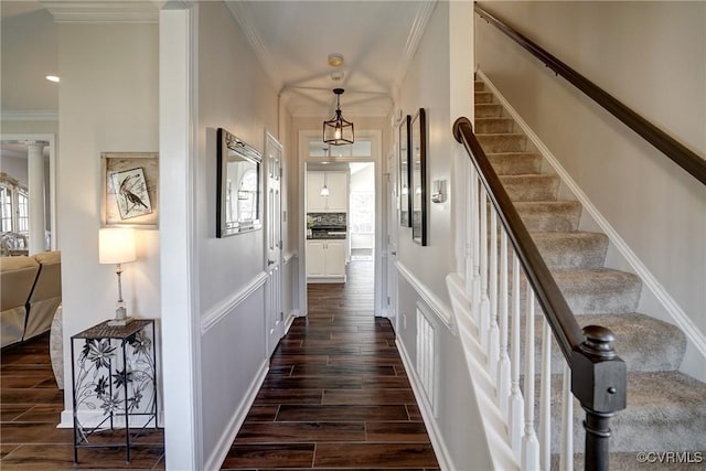 corridor with stairs, ornamental molding, and wood tiled floor