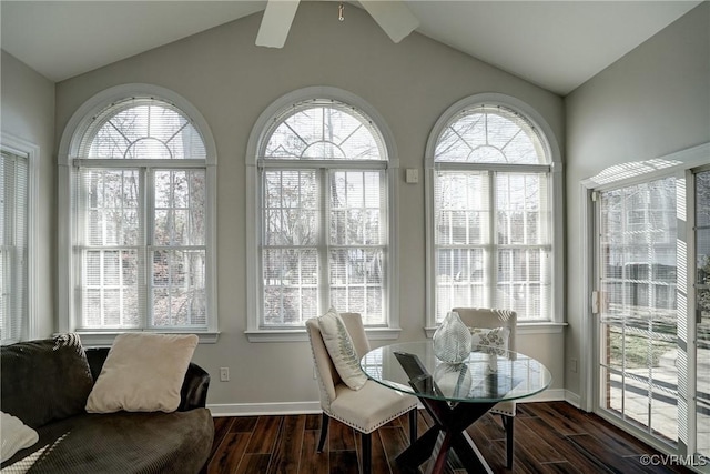 dining area featuring lofted ceiling, a healthy amount of sunlight, and dark wood-style flooring