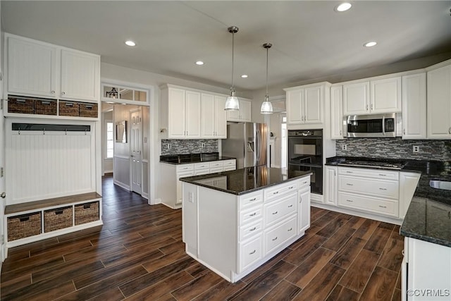 kitchen with stainless steel appliances, a kitchen island, white cabinets, and wood tiled floor