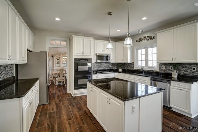 kitchen with white cabinetry, decorative backsplash, appliances with stainless steel finishes, and wood finish floors