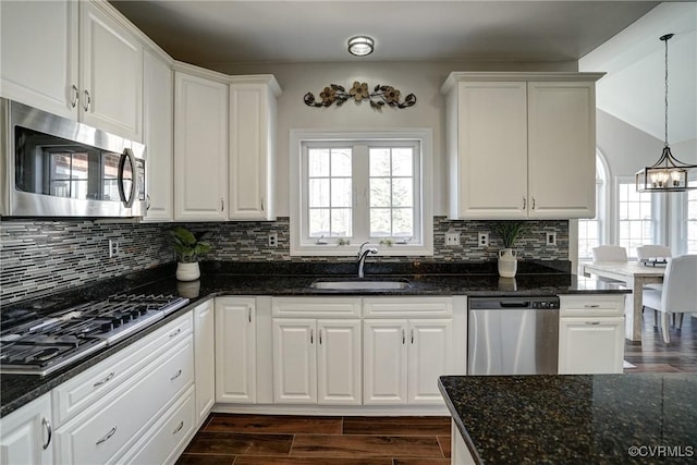 kitchen with decorative backsplash, stainless steel appliances, wood tiled floor, and a sink