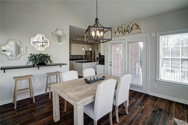 dining room featuring plenty of natural light, lofted ceiling, and wood finish floors