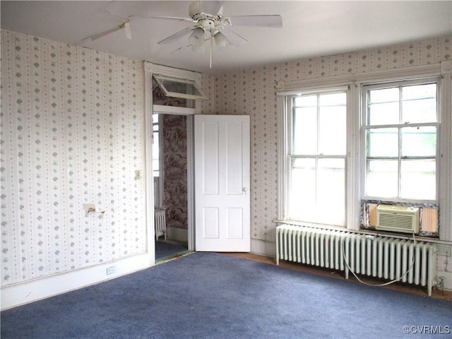 carpeted empty room featuring a ceiling fan, cooling unit, radiator heating unit, and wallpapered walls