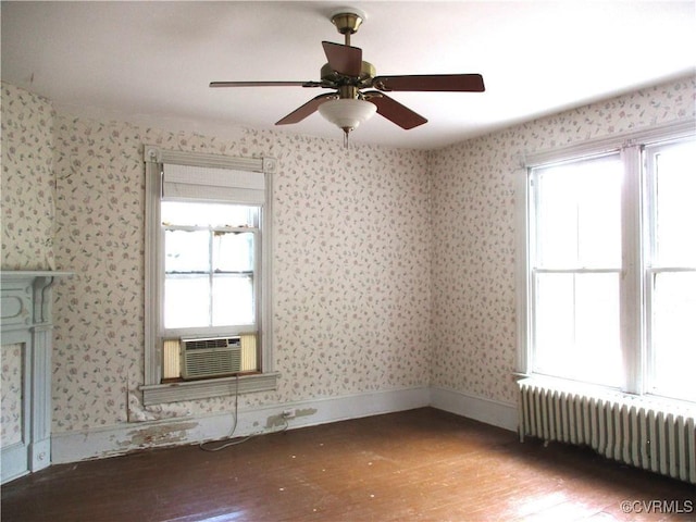 unfurnished room featuring light wood-type flooring, wallpapered walls, and radiator heating unit