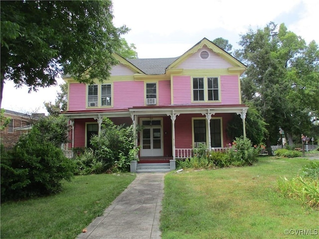 victorian house featuring a porch and a front lawn